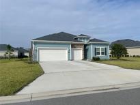 Charming single-Gathering home featuring blue siding, a stone accent, and a two-car garage at 4167 Clifden Dr, Ormond Beach, FL 32174