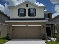 Charming two-story home showcasing a two-car garage and a well-maintained front yard at 4170 Sagefield Dr, Harmony, FL 34773