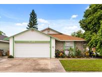 Charming single-story home with a well-maintained lawn, colorful flowerbed, and attached garage at 5324 Barefoot Path, Kissimmee, FL 34746
