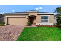 Charming single-story home featuring a well-manicured lawn, brick driveway and a two-car garage at 540 Vitoria Rd, Davenport, FL 33837