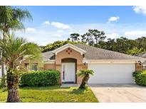 Charming single-story home with a well-manicured lawn and a two-car garage on a sunny day at 8852 Fort Jefferson Blvd, Orlando, FL 32822