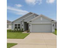 Charming single Gathering home featuring a two car garage, well maintained lawn, and welcoming front entrance at 1168 Citrus Landings Blvd, Davenport, FL 33837