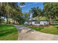 Beautifully renovated home with a long driveway, surrounded by mature trees and professional landscaping at 1206 Culver Rd, Orlando, FL 32825