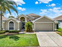 Charming single-story home with a well-manicured lawn and two-car garage at 211 Tavestock Loop, Winter Springs, FL 32708