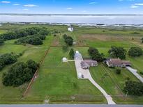 Expansive property featuring a well-maintained lawn, multiple buildings, and mature trees, fully fenced with lake views at 2921 Lake Tohopekaliga Blvd, Kissimmee, FL 34746