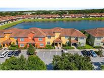 Colorful townhome exteriors with a central lake and parking area at 3061 Beach Palm Ave, Kissimmee, FL 34747