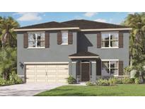 Two-story home featuring a two-car garage, shutters, and a well-manicured lawn at 33604 Seattle Slew Dr, Sorrento, FL 32776
