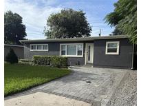 Charming home featuring a neatly landscaped front yard and inviting gray brick driveway at 740 Naples Dr, Orlando, FL 32804