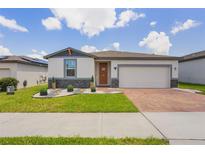 Charming single-Gathering home with a well-manicured lawn, brick driveway, and a two-car garage at 840 Teton St, Haines City, FL 33844