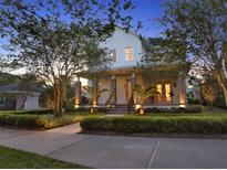 Charming two-story home with a welcoming front porch, stone columns, and manicured landscaping at 8665 Pinter St, Orlando, FL 32827