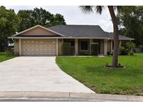 Charming single-story home features a well-manicured lawn and a two-car garage at 910 Amy Ridge Ct, Kissimmee, FL 34747