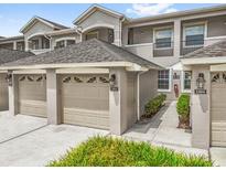 Charming townhome exterior featuring attached garages, neutral color palette, and well-maintained landscaping at 9440 Myrtle Creek Ln # 1003, Orlando, FL 32832