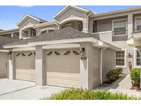 Attached garage with decorative windows and front door access to the home at 9440 Myrtle Creek Ln # 1003, Orlando, FL 32832