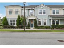 Charming townhome with a well-manicured lawn and colorful exterior paint at 10009 Randal Walk St, Orlando, FL 32832
