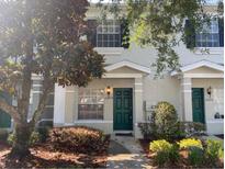 Charming townhome featuring a vibrant green front door and well-maintained landscaping at 10604 Savannah Wood Dr # 84, Orlando, FL 32832