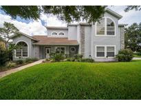 Charming two-story home featuring stone accents, arched windows, and lush landscaping at 13524 Lake Luntz Dr, Winter Garden, FL 34787