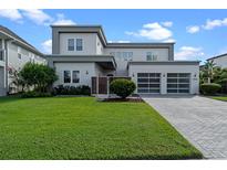 Modern two-story home with well-manicured lawn and three-car garage at 14124 Eliot Ave, Orlando, FL 32827