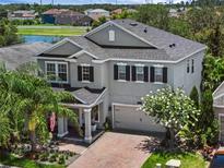 Beautiful two-story home features a well-manicured lawn and a lovely lake view at 14193 Gold Bridge Dr, Orlando, FL 32824