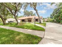 Attractive single-story home with stone accents, complemented by a well-maintained lawn and mature trees at 1424 Mt Laurel Dr, Winter Springs, FL 32708