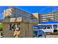 Harbor View condo exterior featuring a multi-story building with covered parking and views of the water at 145 N Halifax Ave # 705, Daytona Beach, FL 32118