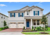 Charming two-story home featuring a blue front door, three-car garage, and manicured landscaping at 16146 Point Rock Dr, Winter Garden, FL 34787