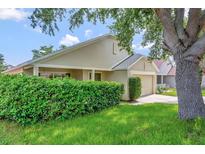 Charming single-Gathering home featuring manicured lawn, mature tree, and attached one car garage at 2081 Newtown Rd, Groveland, FL 34736
