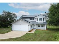 Charming two-story home with solar panels, a well-maintained lawn, and a two-car garage at 2304 Harding Cir, Deltona, FL 32738