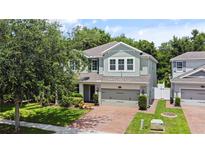 Inviting two-story home with a brick driveway and lush, green landscaping and a two car garage at 2621 Peony Dr, Oviedo, FL 32766