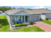 Charming one-story home with a brick driveway, covered porch, and well-manicured landscaping at 410 Winter Bliss Ln, Mount Dora, FL 32757