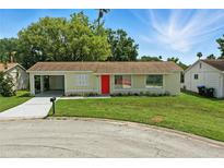 Attractive single-story home with an attached carport and a vibrant green lawn at 4825 Loretta Ln, Orlando, FL 32821