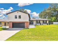 Charming two-story home with a brick and gray two-car garage and beautifully manicured lawn at 614 Mockingbird Ln, Altamonte Springs, FL 32714