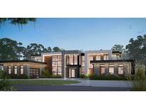 Striking modern home featuring clean lines, expansive windows, and a thoughtfully landscaped yard at 7011 Via Carmel Way, Orlando, FL 32819