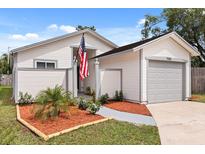 Charming single-Gathering home with a well-manicured front yard, grey trim, and an attached garage at 745 Ashley Ln, Orlando, FL 32825