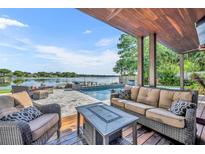 Inviting covered patio features a comfortable seating area, outdoor kitchen and a scenic lake view at 7801 Georgeann St, Winter Park, FL 32792