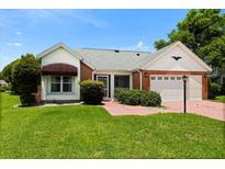 Charming brick and siding home with a well-manicured lawn and a covered entrance, showcasing curb appeal at 956 Chula Ct, Lady Lake, FL 32159