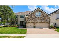 Stunning stone-accented home with three-car garage and meticulously landscaped front yard at 10319 Lavande Dr, Orlando, FL 32836