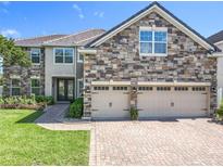 Beautiful exterior features stone accents, a tile roof, and a brick driveway at 10319 Lavande Dr, Orlando, FL 32836