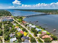 Stunning aerial view of a waterfront home near a bridge with lush landscaping and a beautiful waterway at 105 John Anderson Dr, Ormond Beach, FL 32176