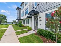 Charming townhome featuring a welcoming front yard and modern architectural details at 12468 Koshiba Aly, Orlando, FL 32827