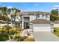 Charming two-story home with a well-manicured lawn and lush tropical landscaping at 14524 Huntingfield Dr, Orlando, FL 32824