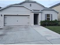 Charming single-story home with a gray exterior, a two-car garage and a well maintained driveway at 1588 Diamond Loop Drive, Kissimmee, FL 34744