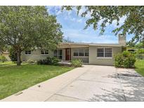 Charming single-story home featuring a brick exterior, mature landscaping, and a long driveway to the front entrance at 203 E Lakeview Ave, Eustis, FL 32726