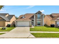 Charming two-story home featuring a two-car garage and well-manicured lawn at 2235 Meadowmouse St, Orlando, FL 32837