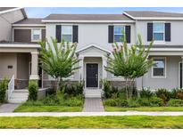 Charming townhome featuring well-manicured landscaping, a welcoming front porch, and classic architectural details at 3099 Ella Way, St Cloud, FL 34771