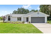 Charming single-story home with a well-manicured lawn, gray roof, and inviting curb appeal at 400 Timbercreek N Dr, Winter Garden, FL 34787