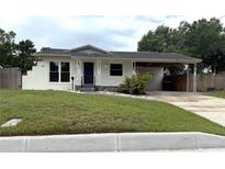 Charming single-story home featuring a covered carport, white exterior paint, and well-maintained front lawn at 5408 Ferdinand Dr, Orlando, FL 32808