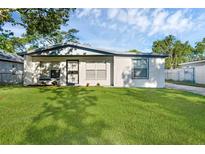 Well-maintained home with a fresh white exterior, landscaping, and a spacious green lawn at 7612 Pomelo Dr, Orlando, FL 32819