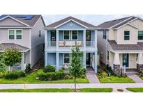 Charming two-story home with blue exterior, balcony, well-manicured lawn, and inviting curb appeal at 15133 Summer Harvest St, Winter Garden, FL 34787