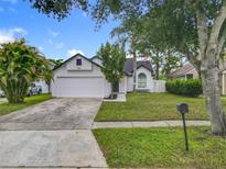 Charming one-story home boasts a well-maintained lawn, two-car garage, and beautiful landscaping at 2160 Churchill Downs Cir, Orlando, FL 32825
