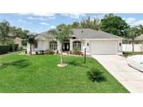 Beautiful one-story home boasts a well-manicured lawn, vibrant landscaping, and a two-car garage at 3534 Woodley Park Pl, Oviedo, FL 32765